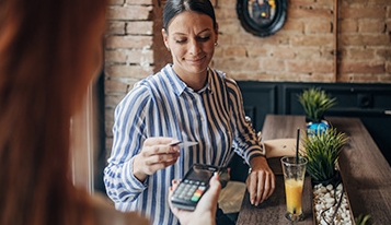 Woman using a card to purchase shopping
