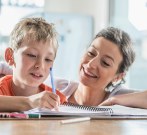 A mum and a son completing homework together.